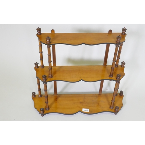 1075 - A C19th satinwood hanging wall shelf with thee shaped tiers united by faux bamboo turned supports