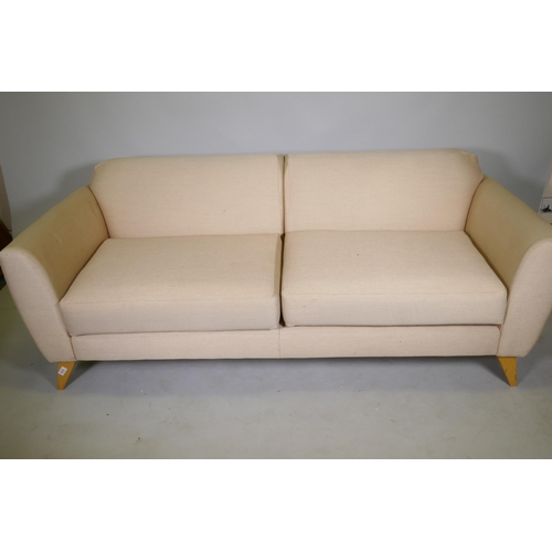 1079 - A contemporary design two seater sofa with linen covers, raised on splay supports, 188cm wide