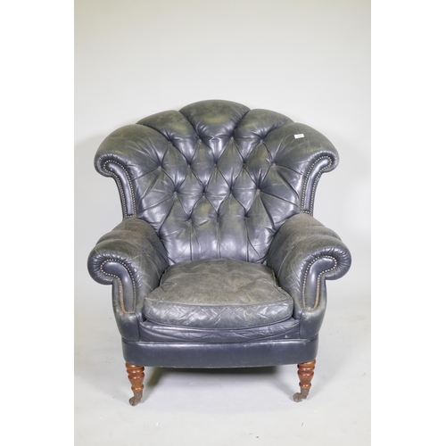 1081 - A Victorian style button back leather armchair, with scroll arms, fan back and studded detail, raise... 