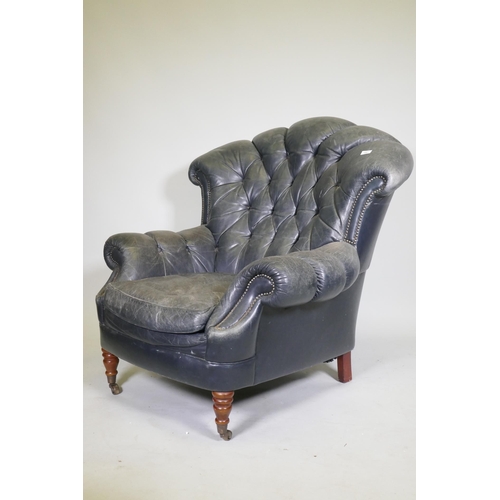 1081 - A Victorian style button back leather armchair, with scroll arms, fan back and studded detail, raise... 