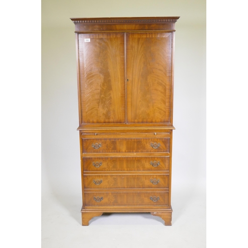 1083 - A mahogany tallboy cabinet with two cupboards over a brushing slide and four drawers, raised on brac... 