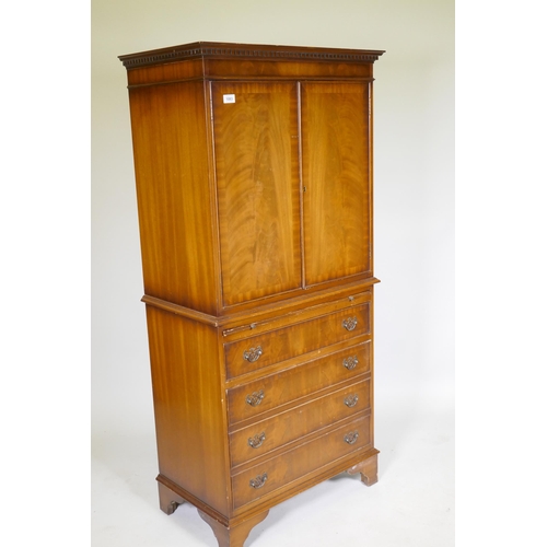 1083 - A mahogany tallboy cabinet with two cupboards over a brushing slide and four drawers, raised on brac... 