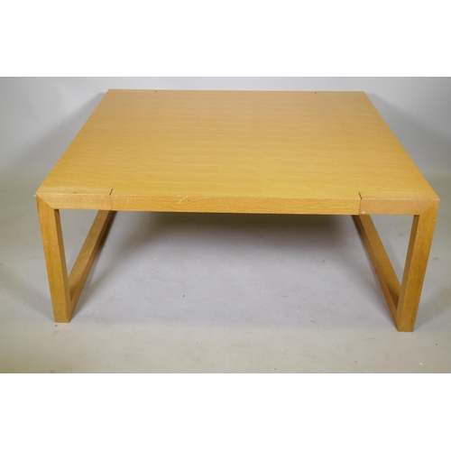 1095 - A contemporary blond oak coffee table, raised on square end supports, 120 x 120 x 48cm