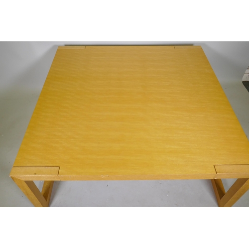 1095 - A contemporary blond oak coffee table, raised on square end supports, 120 x 120 x 48cm