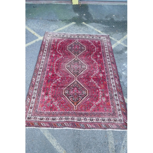 1116 - A Persian washed red ground full pile Qashqai tribal carpet, 216 x 294cm