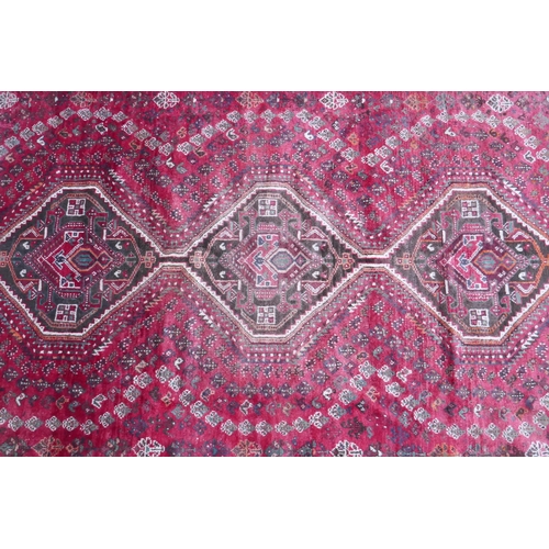 1116 - A Persian washed red ground full pile Qashqai tribal carpet, 216 x 294cm