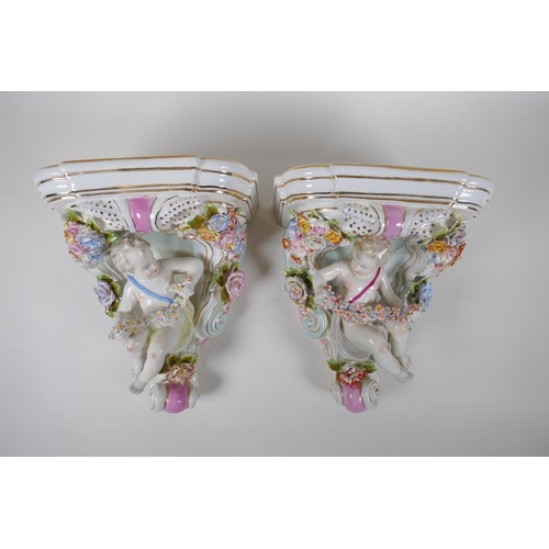 112 - A pair of Dresden style porcelain wall brackets decorated with putti and flowers, 24cm high