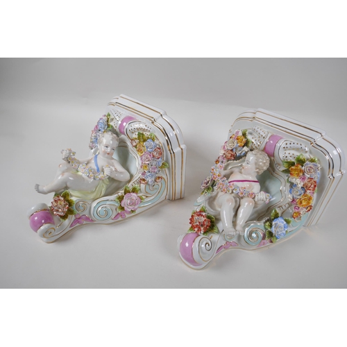 112 - A pair of Dresden style porcelain wall brackets decorated with putti and flowers, 24cm high