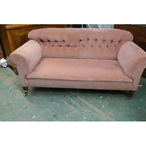 1121 - A Hampton & Sons, London, two seater Chesterfield sofa raised on turned front supports and brass... 