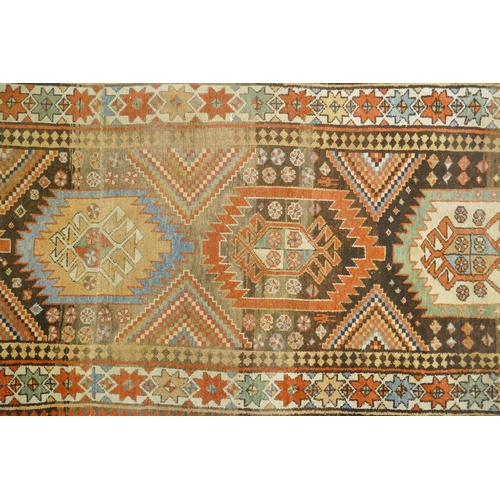 1129 - A multi colour ground Kurdish Kazak wool runner with a geometric medallion design on a brown field, ... 