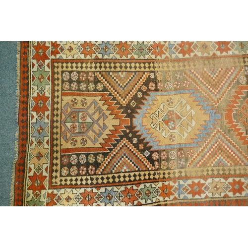 1129 - A multi colour ground Kurdish Kazak wool runner with a geometric medallion design on a brown field, ... 