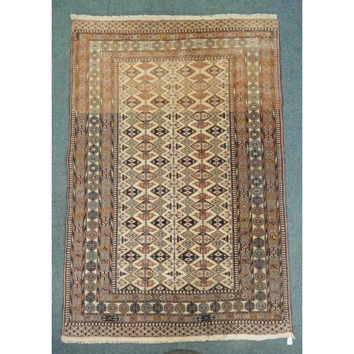 1132 - An Afghan faded red and black ground wool rug with Bokhara style design, 128 x 186cm