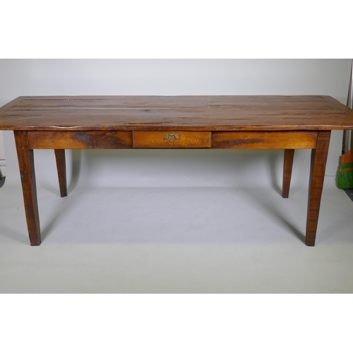 1136 - A French style oak farmhouse table with single drawer and cleated plank top, raised on square taperi... 