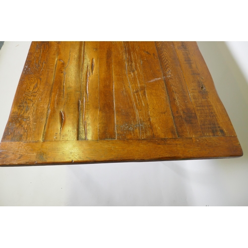 1136 - A French style oak farmhouse table with single drawer and cleated plank top, raised on square taperi... 