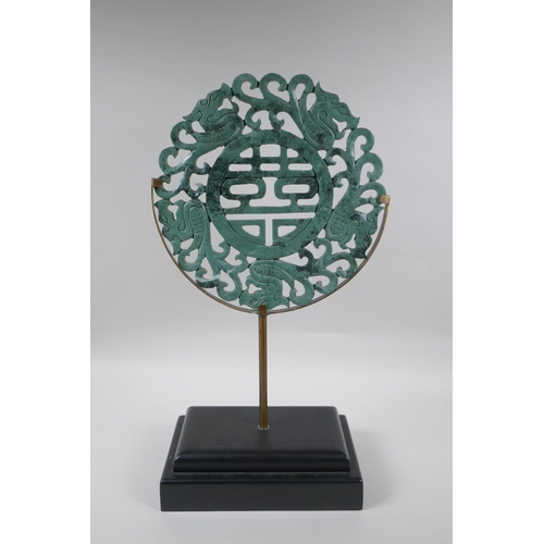 114 - A Chinese carved mottled green jade/hardstone rondel with auspicious symbol and dragon decoration, o... 