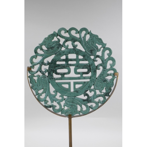 114 - A Chinese carved mottled green jade/hardstone rondel with auspicious symbol and dragon decoration, o... 