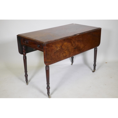 1141 - A Georgian drop leaf Pembroke table, with single end drawer, raised on ring turned tapering supports... 