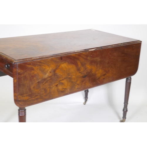 1141 - A Georgian drop leaf Pembroke table, with single end drawer, raised on ring turned tapering supports... 