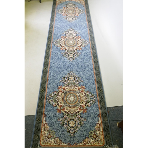 1190 - An Iranian fine woven blue ground runner with a medallion design and darker blue border, 80 x 310cm