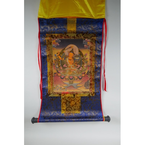 120 - A Tibetan printed thangka in a silk scroll mount with gilt illuminated details, 48 x 62cm