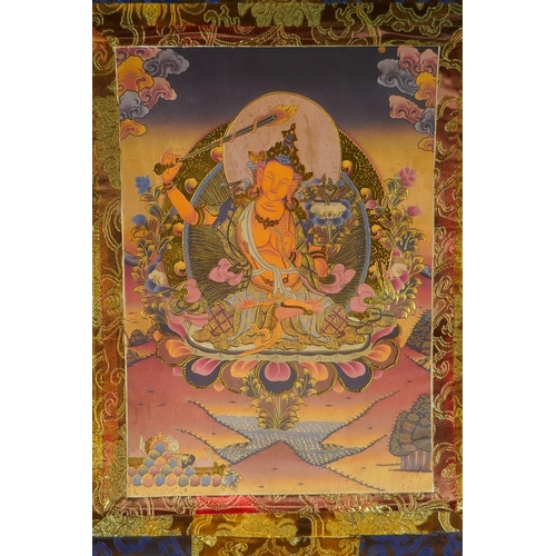 120 - A Tibetan printed thangka in a silk scroll mount with gilt illuminated details, 48 x 62cm