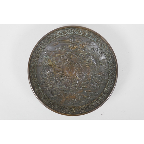 125 - A Chinese bronze dish with raised kylin decoration, Xuande 4 character mark to base, 18cm diameter