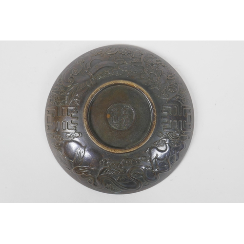 125 - A Chinese bronze dish with raised kylin decoration, Xuande 4 character mark to base, 18cm diameter