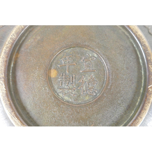 125 - A Chinese bronze dish with raised kylin decoration, Xuande 4 character mark to base, 18cm diameter