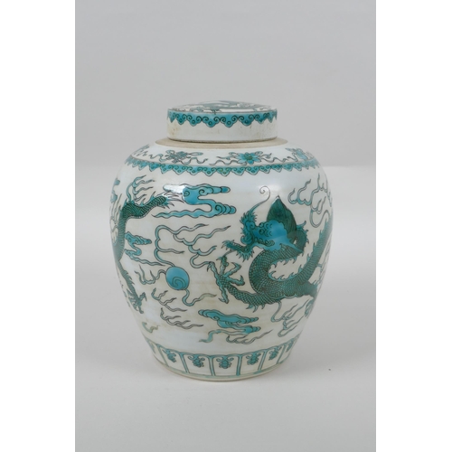 128 - A Chinese porcelain ginger jar and cover, decorated with emerald green dragons, chasing the flaming ... 