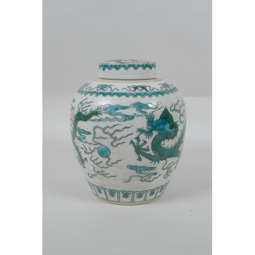 128 - A Chinese porcelain ginger jar and cover, decorated with emerald green dragons, chasing the flaming ... 