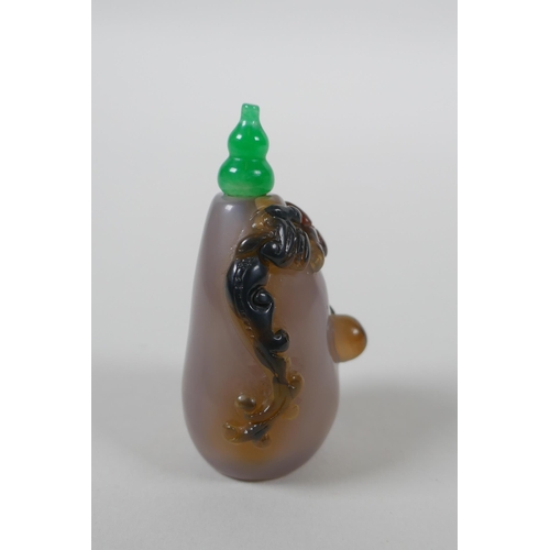 133 - A Chinese agate snuff bottle with carved kylin and ruyi decoration, 6cm high