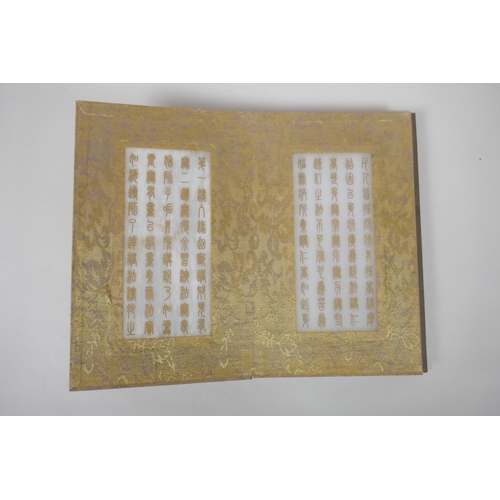 140 - A Chinese wood and silk bound book containing white jade tablet pages with chased and gilt inscripti... 