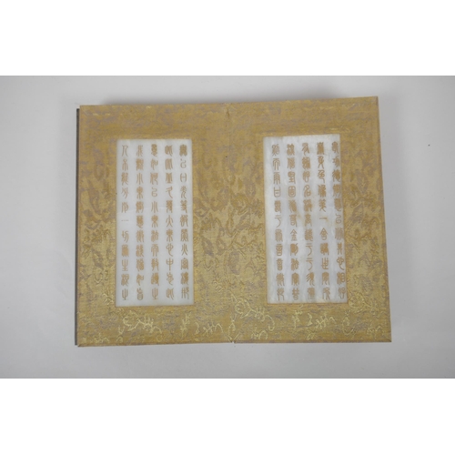 140 - A Chinese wood and silk bound book containing white jade tablet pages with chased and gilt inscripti... 