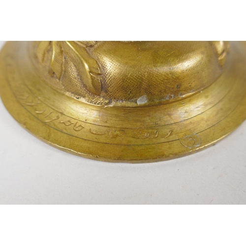 154 - An unusual brass candlestick with Arabic inscription to the base and raised insect decoration, 16cm ... 