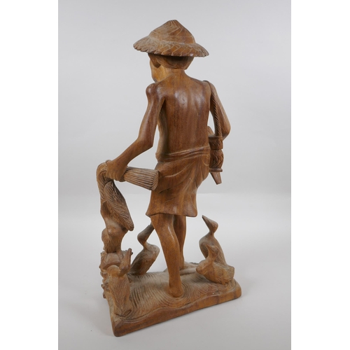 166 - An oriental carved wood figure of a farmer surrounded by ducks, 46cm high