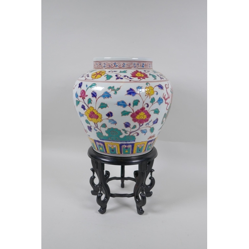 168 - A Chinese polychrome porcelain jar decorated with kylin and lotus flowers, on a carved hardwood stan... 