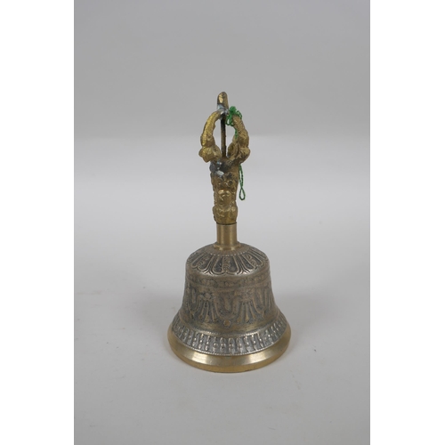 212 - A Tibetan bronze singing bowl and beater with script decoration, a brass ceremonial bell with silver... 