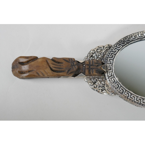 226 - A Chinese white metal hand mirror with repousse dragon and phoenix decoration and a carved hardstone... 