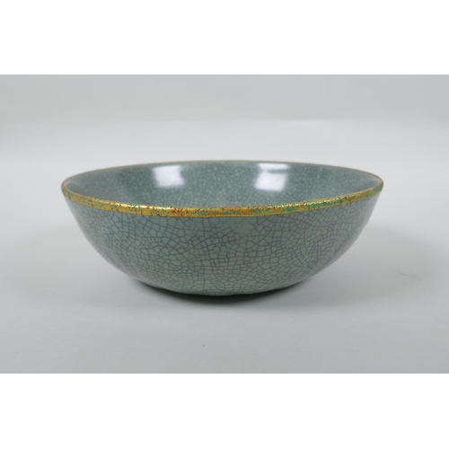 230 - A Chinese celadon crackle glazed porcelain bowl with a gilt metal rim and decorated with chased char... 