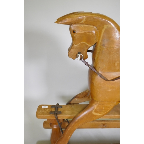 24 - A vintage pine rocking horse with carved saddle, 107cm high, 144cm long