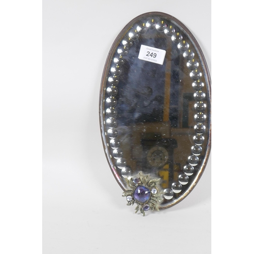 249 - A small antique mirror with bevelled and cut glass and applied ornament set with paste stones, 30cm ... 