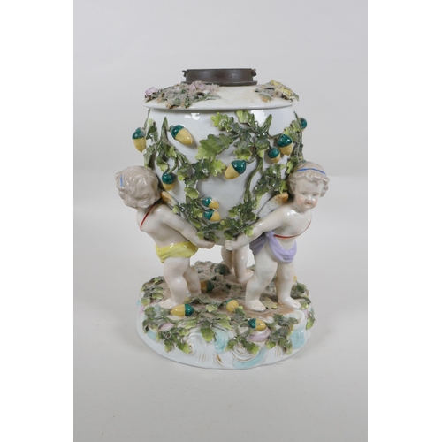 264 - An antique continental porcelain oil lamp converted to electricity, decorated with three winged putt... 