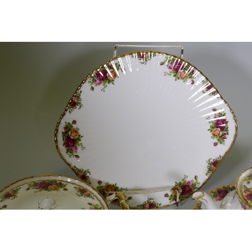 27 - A Royal Albert Country Rose six place dinner service, with serving plates, tureens etc, appears unus... 