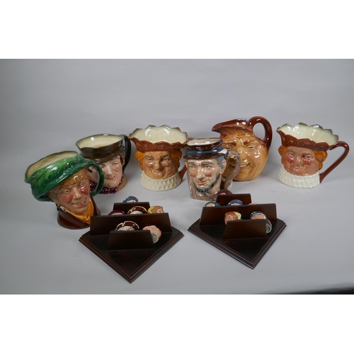 299 - A set of six Royal Doulton mask jugs and twelve miniature jugs with display shelves