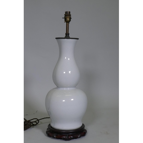 40 - A white glazed porcelain table lamp in the form of an oriental vase, with brass mount and carved woo... 