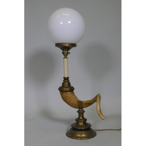 46 - A table lamp in the form of a ram's horn, with brass mounts and opaline glass shade, 68cm high