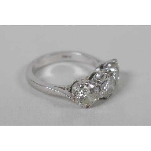 608 - A platinum set three brilliant cut diamond ring, the central stone approx 0.95ct, flanking two stone... 