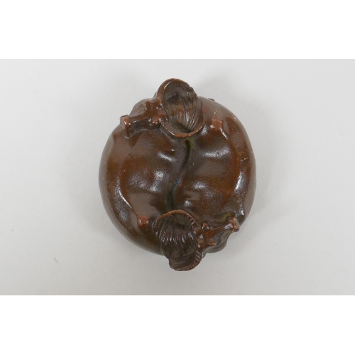 61 - An oriental cast bronze rondel in the form of two water buffalo and a Yin Yang emblem, 6cm diameter