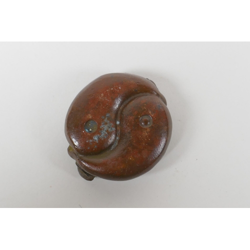 61 - An oriental cast bronze rondel in the form of two water buffalo and a Yin Yang emblem, 6cm diameter