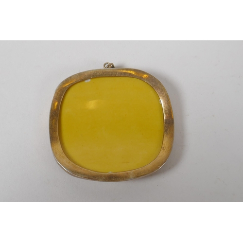 611 - A Chinese imperial yellow porcelain shard in a yellow metal pendant mount, 6cm x 5.5cm 